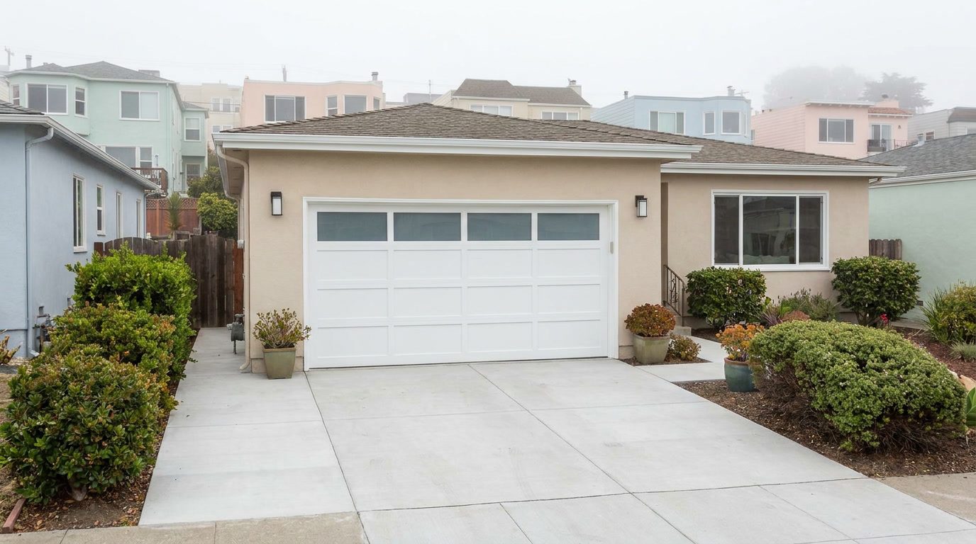 Brand new modern white sectional garage door with frosted glass top row installed on the same Sunset District San Francisco stucco home, after replacement